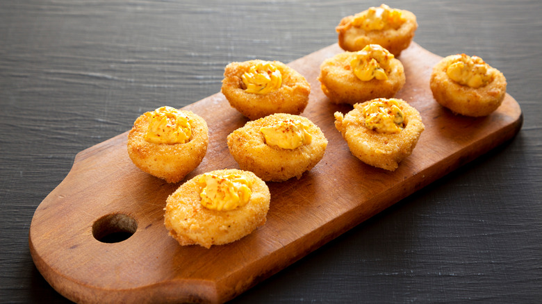 deep fried deviled eggs on wooden board