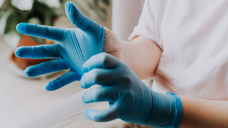 Rubber gloves being put on hands