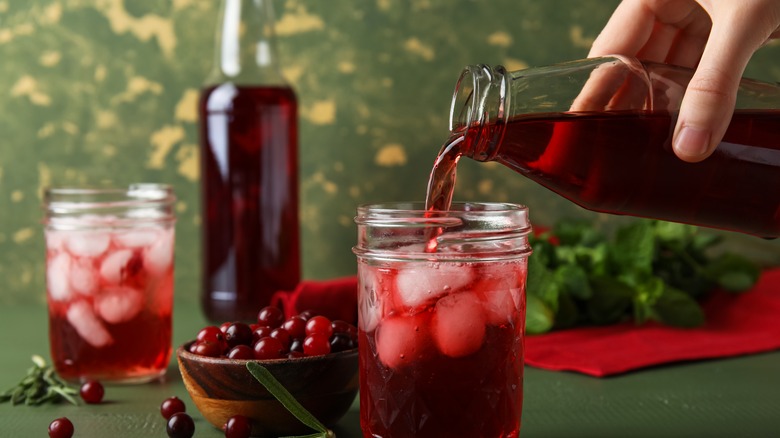 pouring cranberry juice into a glass