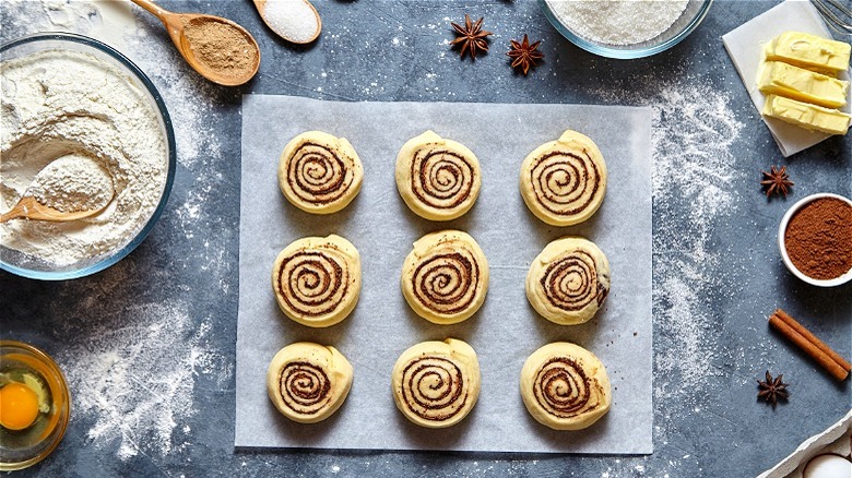 Raw cinnamon rolls on parchment paper  