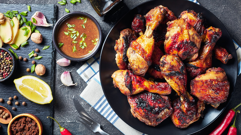 plate of jerk chicken drumsticks with dipping sauce