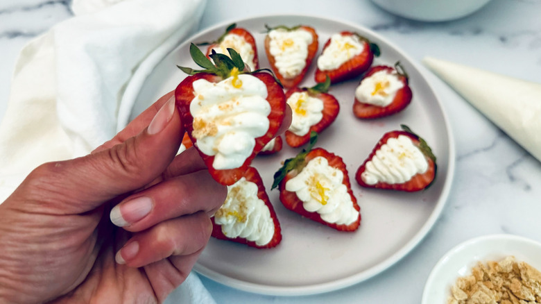 holding cheesecake stuffed strawberry