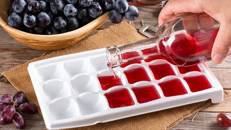 hand pouring wine into ice tray