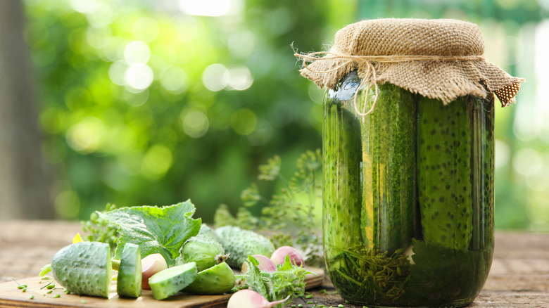 Jar of homemade pickles with garlic and sliced cucumbers