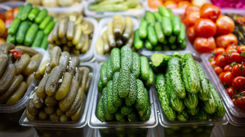 Trays of various pickles at a deli