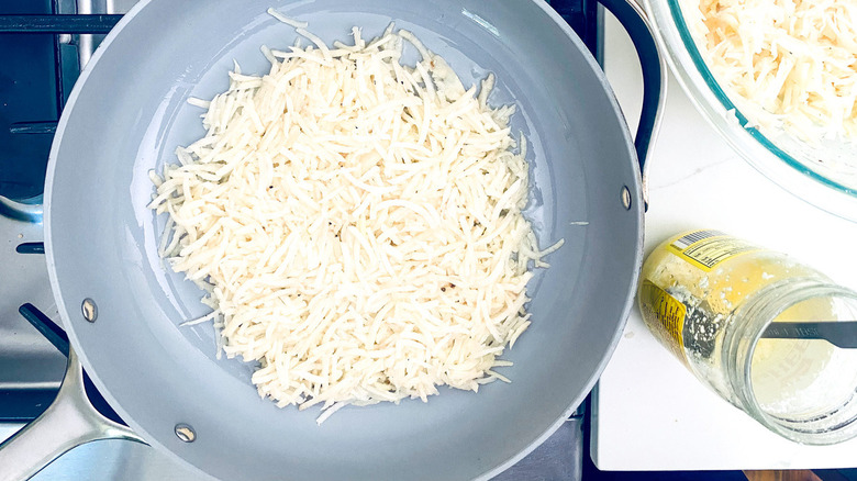 shredded potatoes in frying pan