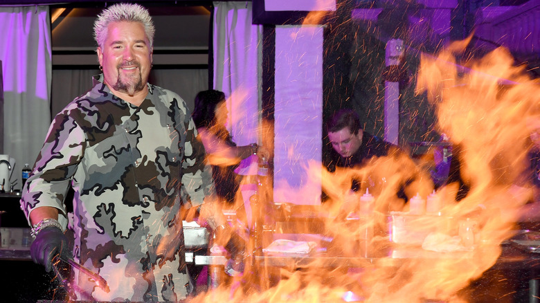 Guy Fieri behind flaming grill