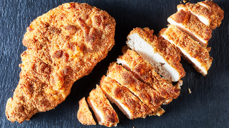 Fried chicken breasts on black background