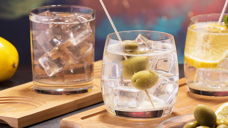 3 cocktail glasses with ice cubes and garnishes