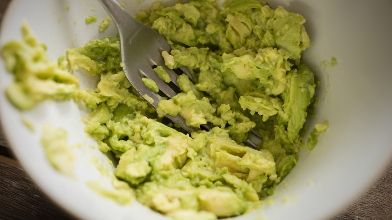 fork mashing avocado