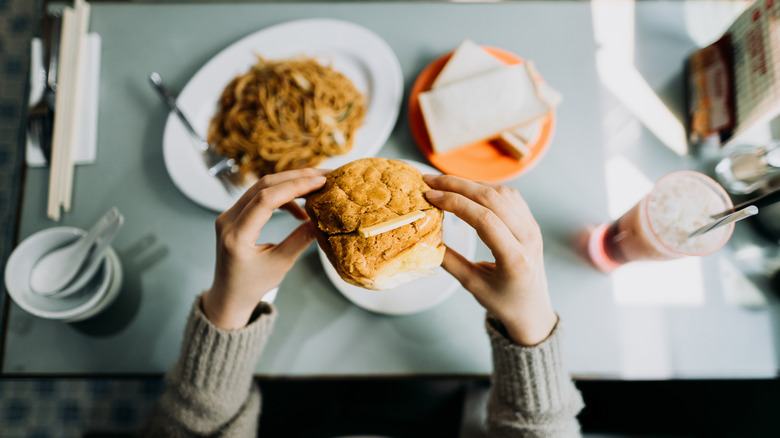 A person eating a pineapple bun