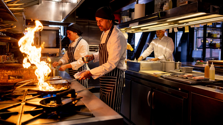 chefs cooking in restaurant kitchen