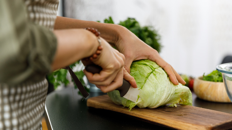 Person cutting lettuce with knife