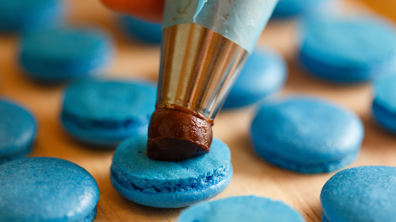 filling macarons on baking sheet