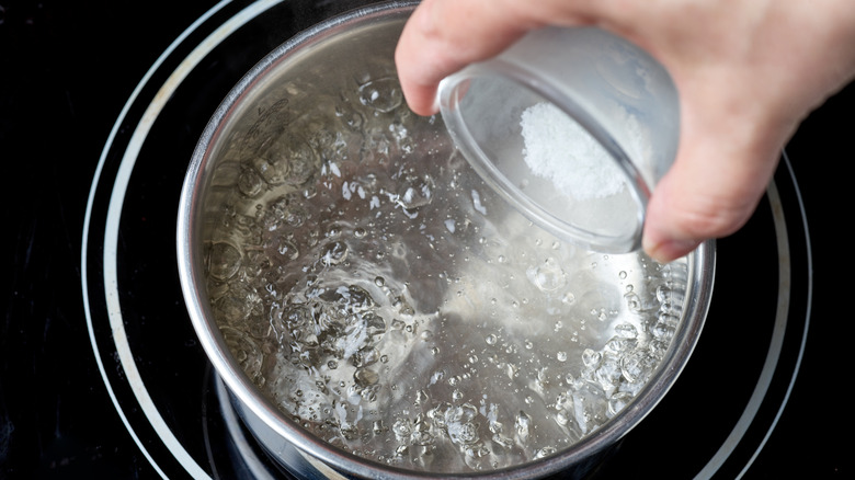 adding salt to pot of boiling water 