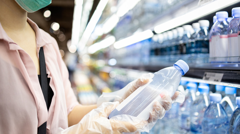 Woman checking bottled water label