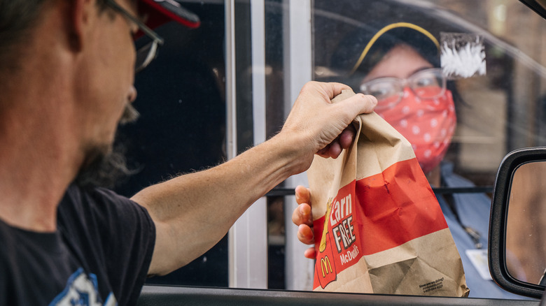 A customer grabs McDonald's bag from drive thru