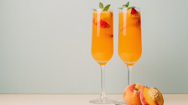 Two peach bellinis with peaches