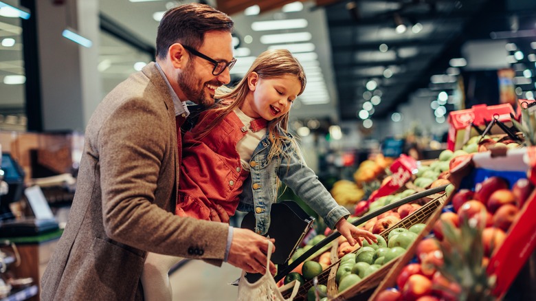 Parent and child shopping for produce in a grocery store