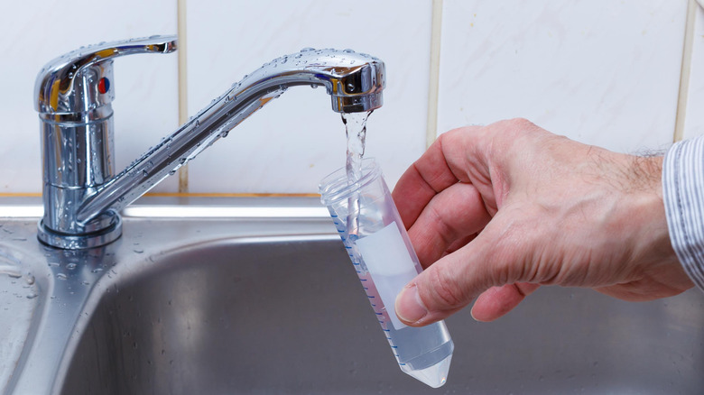 Pouring tap water into test tube