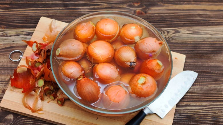 Yellow onions in bowl of water 