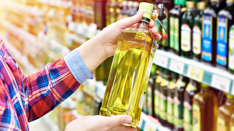 person holding oil in store