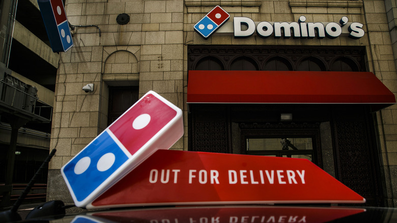 The top of a Domino's delivery vehicle in front of a location