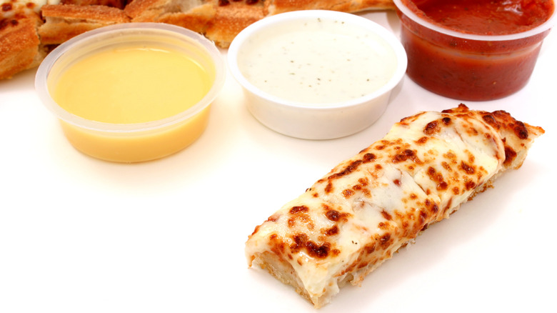 pizza next to dipping sauces