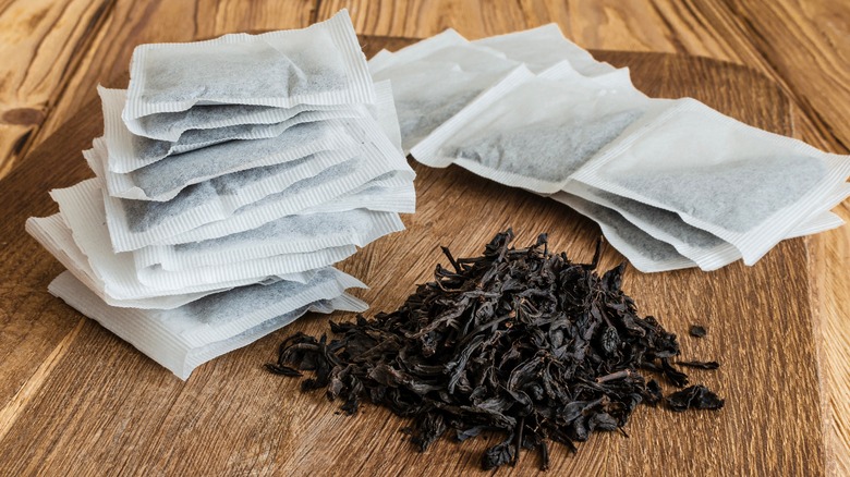 tea bag tea and loose leaf tea on wooden board