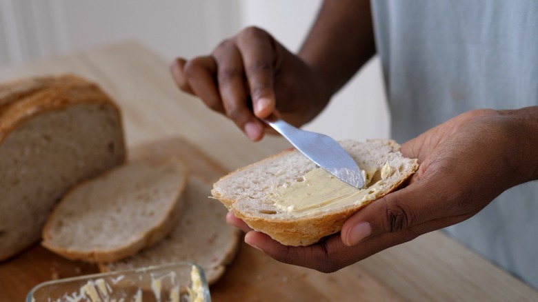 spreading softened butter on toast