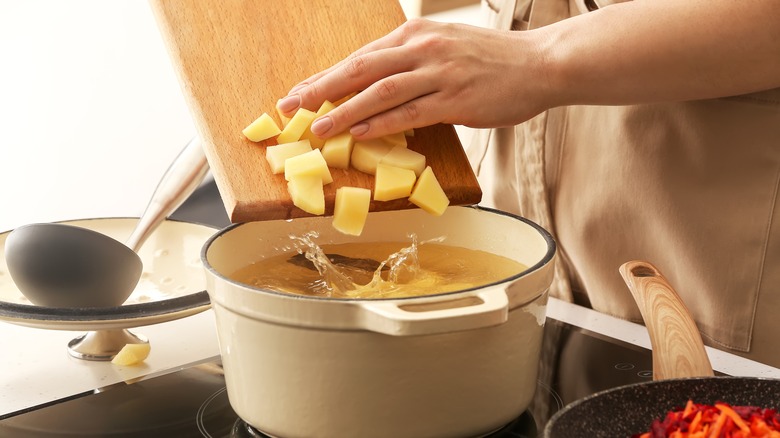 chopped potatoes going into pot