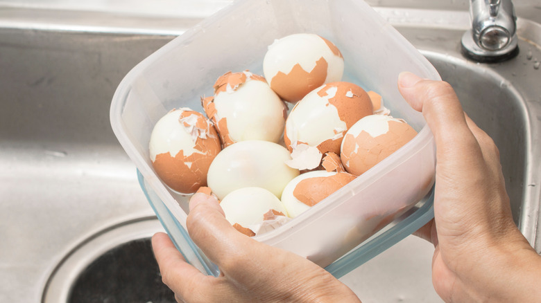 partially peeled eggs in container