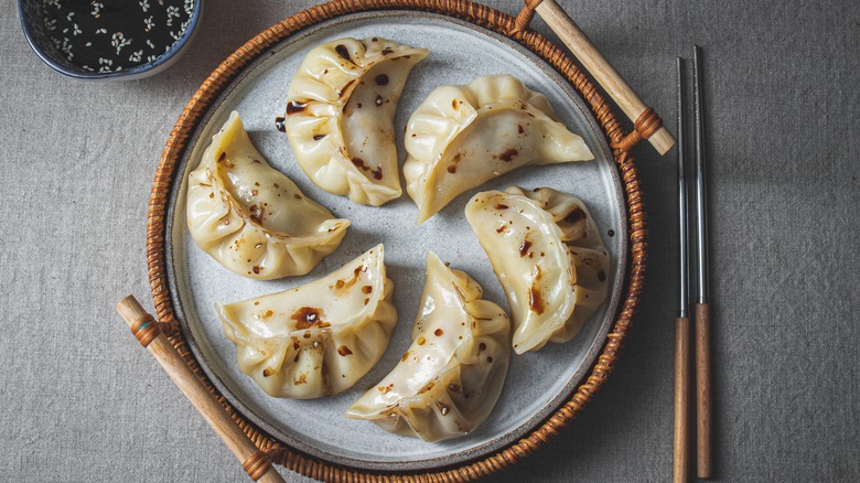 Gyoza on plate, chopsticks, sauce