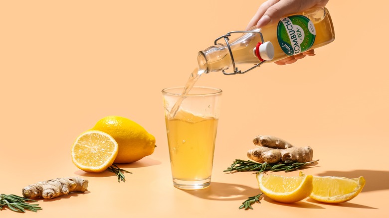 Person pouring kombucha into glass