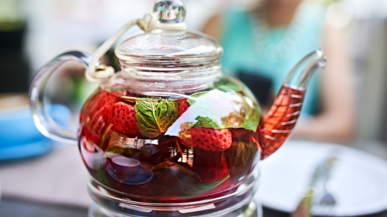 a pot of tea brewing with fruit