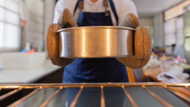 Person taking cake pan out of oven