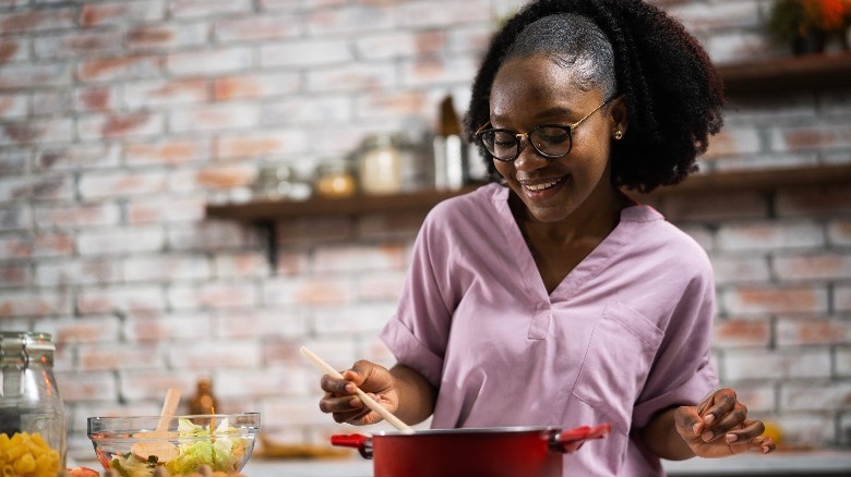 woman stirring a red pot