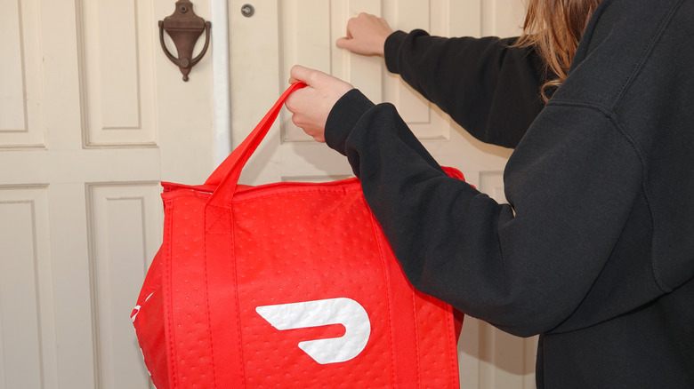 food courier carrying DoorDash bag