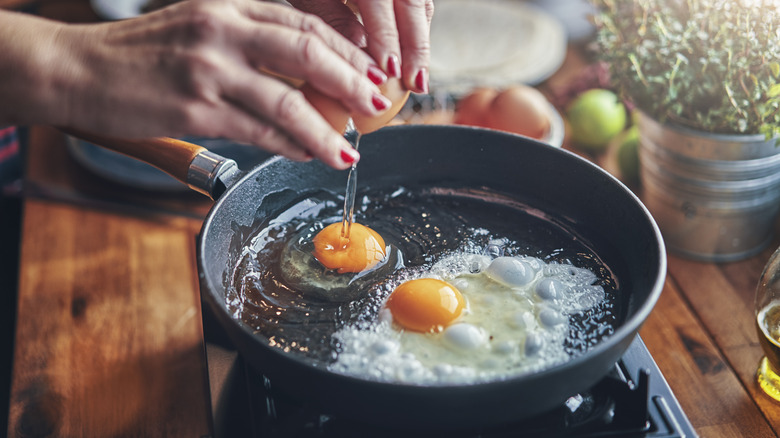 domestic cook frying eggs