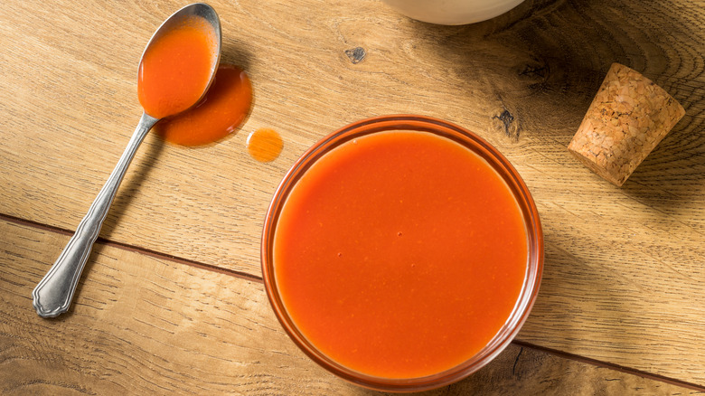 Bowlful and spoonful of buffalo sauce