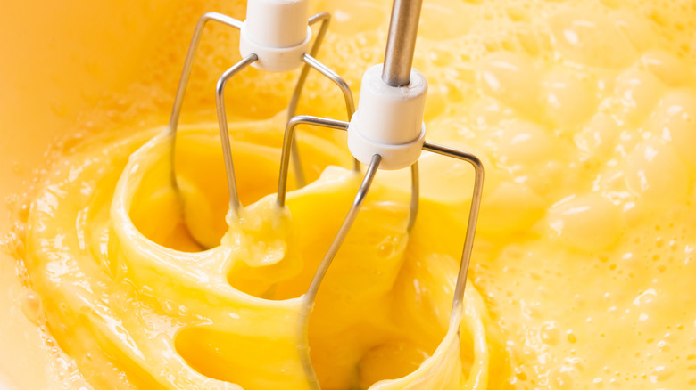 Eggs getting blended by electric whisks