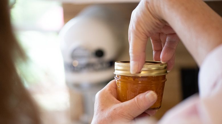 Woman unscrewing canning ring