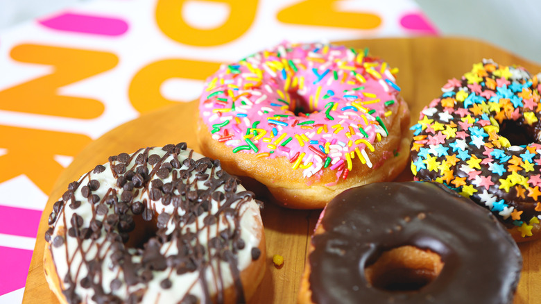 Dunkin' donuts on wooden platter with box in background