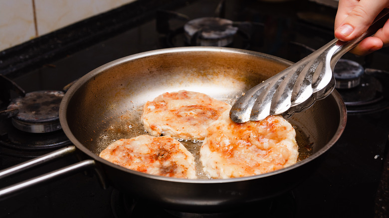 turkey burgers frying in a pan