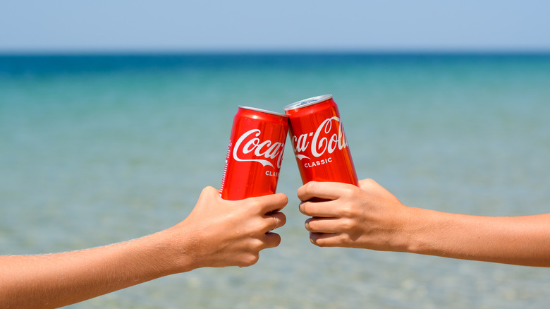 Two hands cheering with Coca-Cola