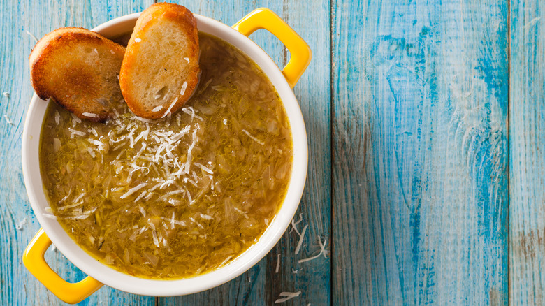 French onion soup in a pot with sliced bread from above