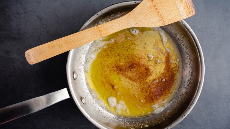 Brown butter in pan with wooden spoon