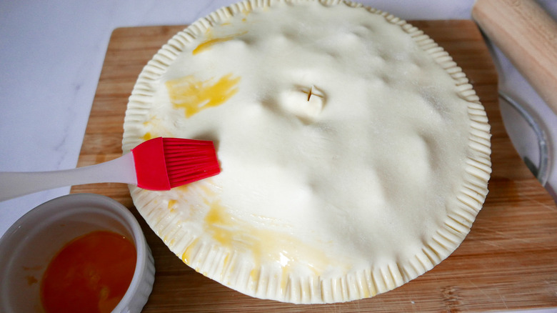 brushing yolk on pie crust