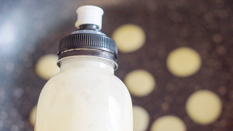 bottle with pancakes in background