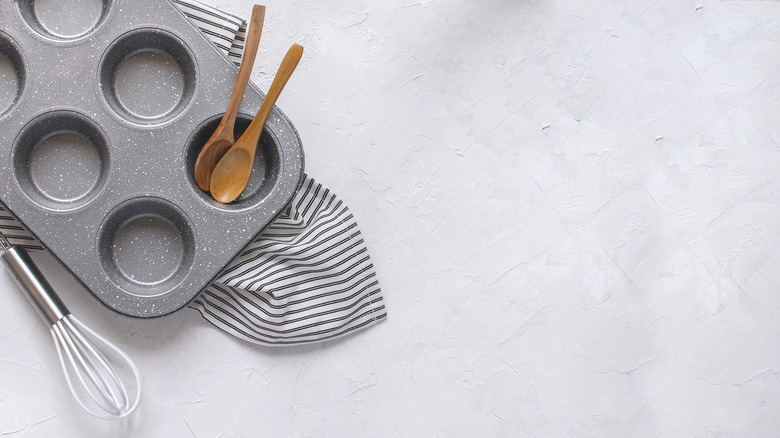 empty muffin tin with wooden spoons